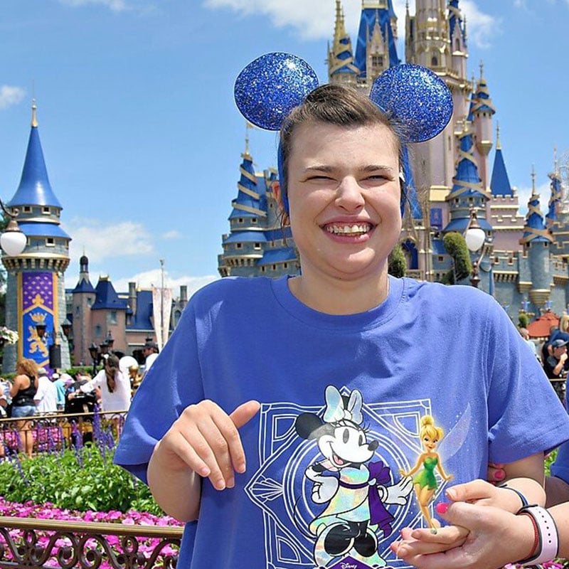 autistic-woman-smiling-at-disney-in-disney-outfit