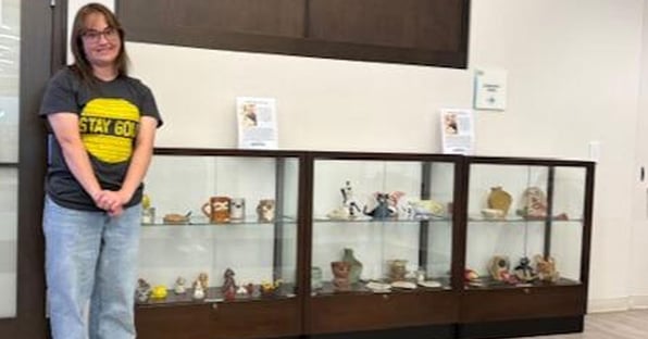 Katy Saas standing by a display case in the library.jpg