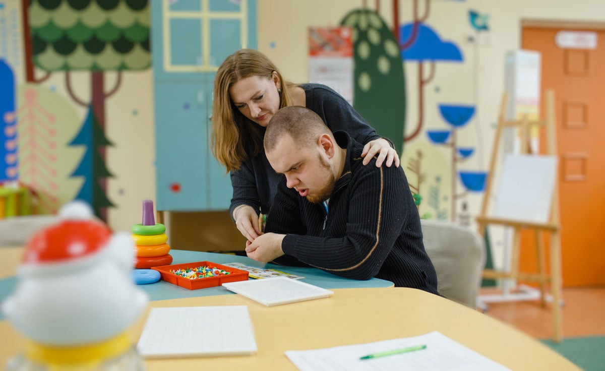 female-psychologist-works-with-an-adult-boy-with-autism