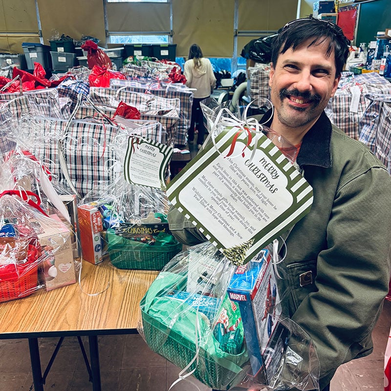 man holding gift basket at fundraiser event