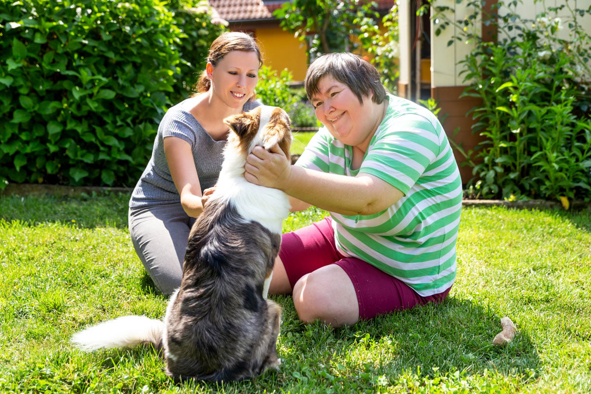 mentally-disabled-woman-with-a-second-woman-and-a-companion-dog