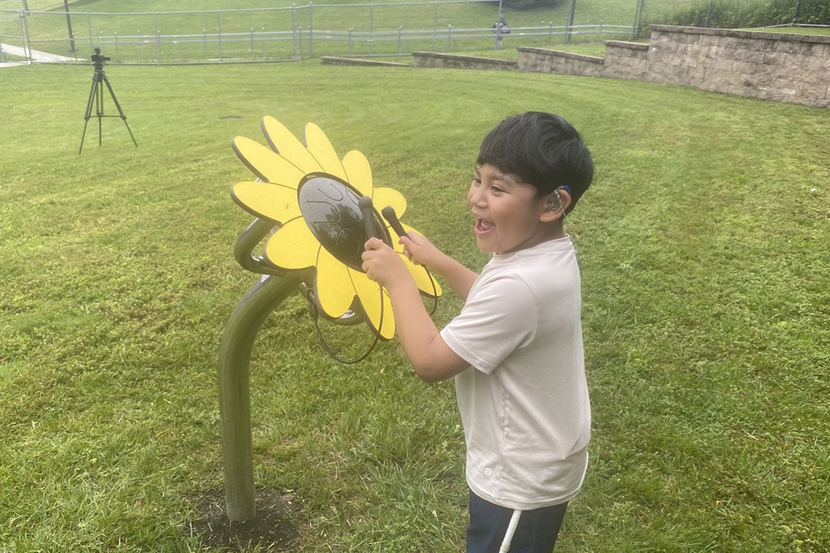 student-playing-sunflower-drums-outside-in-park