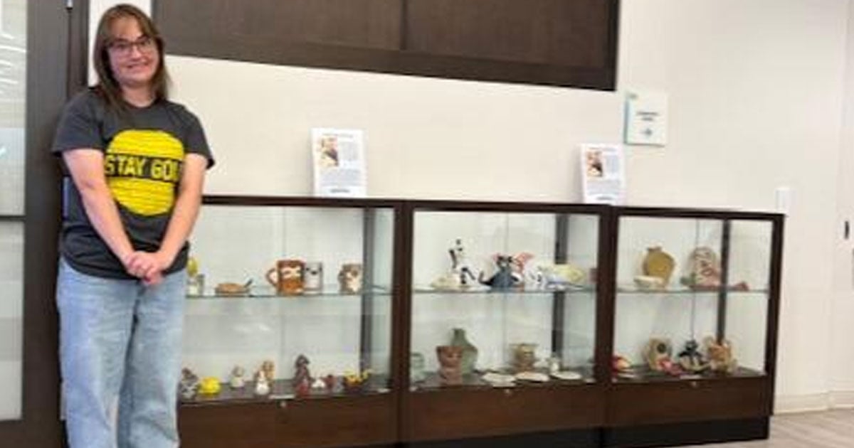 Katy Saas standing by a display case in the library.jpg