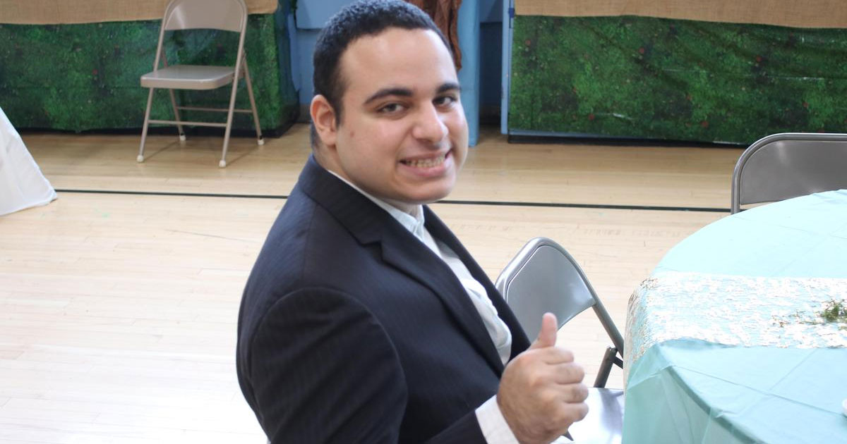 Young man in a suit giving a thumb's up